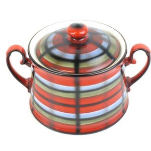 Może przedstawiać: Ceramiczna cukiernica z pokrywką, z czerwono-czarno-białym wzorem w paski. Miska ma dwa uchwyty i czerwone pokrętło na pokrywce. Projekt jest symetryczny i na białym tle.