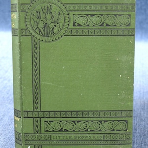 Puede incluir: Un libro verde vintage con elementos decorativos negros. La portada presenta un diseño floral circular y el texto "LITTLE, BROWN & CO.". El lomo del libro muestra el título "POEMS" y el nombre del autor.