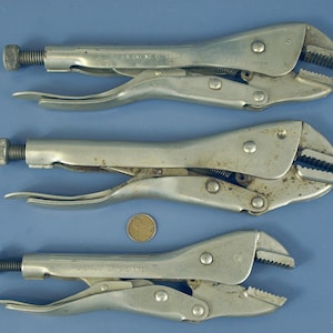 May include: Three silver-colored metal locking pliers with adjustable knurled screws at the ends and serrated jaws. A copper-colored United States one-cent coin is positioned between the middle and bottom pliers for scale reference.