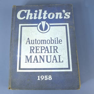 Könnte beinhalten: Ein blaues gebundenes Chilton's Automobile Repair Manual aus dem Jahr 1958. Das Frontcover zeigt den weißen Schriftzug Chilton's, Automobile REPAIR MANUAL und die Jahreszahl 1958 sowie einen weißen quadratischen Rahmen und ein Logo oben mittig.