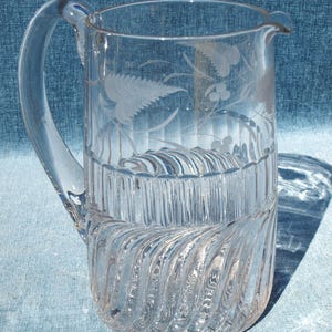 Vacker vintage kanna i klart glas med etsade florabladmönster och virveldesign och handblåst handtag
