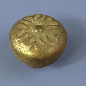 Puede incluir: Un pomo de metal dorado con un diseño floral decorativo.