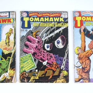 Puede incluir: Tres cómics vintage con el personaje "Tomahawk". Las portadas son rojas, blancas y azules con ilustraciones del personaje en acción. El texto en las portadas dice "Tomahawk" y "Rip Roaring Rangers".