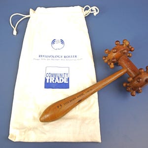 Puede incluir: Una taza de cerámica blanca con asa negra y el texto "But First, Coffee" en negrita negra. La taza se encuentra sobre un fondo neutro, resaltando su diseño sencillo.