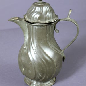 Cafetera/chocolatera alemana antigua de peltre rococó, circa 1800. Buen estado con importantes señales de uso. Marcada "FK".