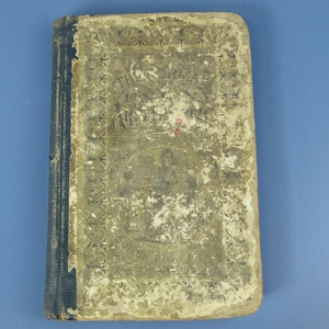 May include: A vintage book, titled "The Normal Union Arithmetic" by Edward Brooks, A.M. The cover shows signs of age, with faded text and illustrations. The spine is dark blue. The book's overall appearance suggests it is a vintage item, with a worn cover.
