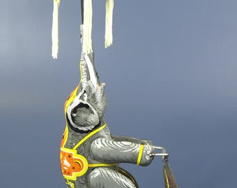 Juguete antiguo de hojalata Schylling con forma de elefante de circo en triciclo, de cuerda, en excelente estado de funcionamiento.