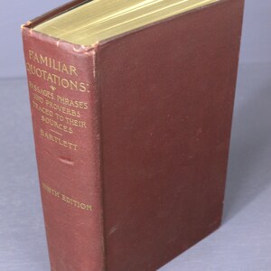 Könnte beinhalten: Ein dunkelrotes Hardcover-Buch mit dem Titel "Familiar Quotations: Passages, Phrases and Proverbs Traced to Their Sources - Bartlett" in goldener Schrift. Das Buch ist eine neunte Auflage und wurde von Little, Brown & Co. veröffentlicht.