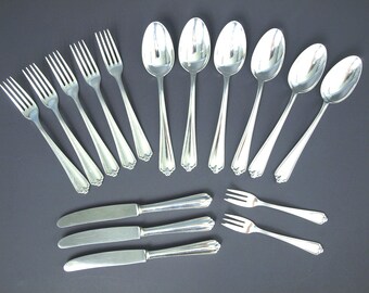 May include: A set of stainless steel flatware including five forks, five spoons, three dinner knives, and two small dessert forks. Each piece features a polished silver finish with a simple, smooth handle design and a subtle decorative detail at the base.