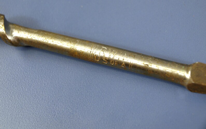 May include: Close-up of a vintage metal tool with a brass finish. The tool has the inscription "IRWIN USA 2" etched into the metal. The tool is set against a blue background.