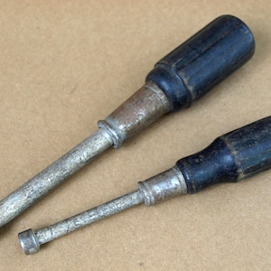 Par de destornilladores antiguos Stevens Spintite: 7/16 n.° 3414 y 5/16 n.° 3410, ambos con mangos de madera negros.