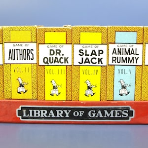 May include: A collection of vintage card games, including "Old Maid," "Authors," and "Crossword," displayed in a red box labeled "Library of Games." Each game box has a unique color and illustration, with the game titles prominently displayed.
