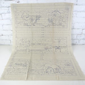 May include: A beige fabric panel featuring three distinct farm-themed embroidery patterns outlined in blue ink. Each section contains labeled letters for color-coding, depicting cows, barns, houses, fences, and a horse. Text reads No 510 Sultana.