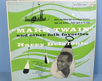 May include: A vintage vinyl record album cover featuring a black and white photo of Harry Belafonte, a well-known singer and actor, against a backdrop of green and blue waves. The album title is "Mark Twain" and other folk favorites. The album cover is from RCA Victor.