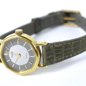 May include: A gold-toned Pulsar quartz watch with a gray face and a green alligator-embossed leather band.