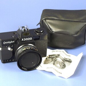 May include: A black Quickshot X3000 35mm camera with a lens cap, a black carrying case, and an owner's manual. The camera has a silver flash and a textured grip. The owner's manual is white with black text and a camera illustration.