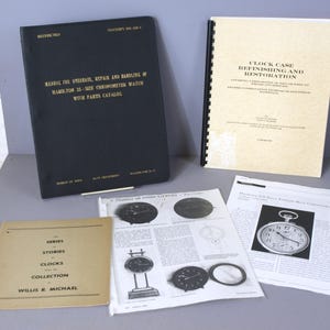 May include: A collection of books and pamphlets about clock repair and restoration. The books have black, brown, and white covers with gold lettering. The text on the covers includes "Manual for overhaul, repair and handling of Hamilton 25-size chronometer watch with parts catalog", "Clock Case Refinishing and Restoration", and "Series of Stories of Clocks Collection Willis R. Michael".