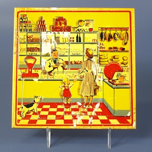 Può includere: Un'insegna quadrata gialla vintage con un pavimento a scacchi rossi e bianchi. L'insegna raffigura una scena di negozio di alimentari con un negoziante, clienti e un cane. Gli scaffali sono pieni di merci e l'insegna ha un bordo rosso.