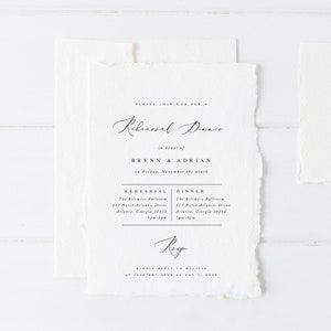 May include: A white invitation with a torn edge, announcing a rehearsal dinner for Brynn and Adrian on Friday, 9th November. The invitation includes the location and time for both the rehearsal and dinner at The Biltmore Ballroom in Atlanta, Georgia.