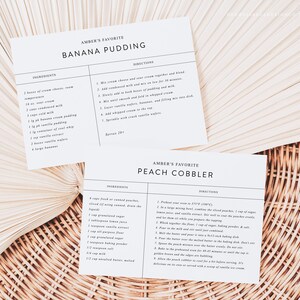 May include: Two recipe cards with handwritten instructions for Amber's favorite Banana Pudding and Peach Cobbler. The cards are on a woven background.