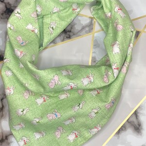 May include: A green bandana with a white bunny rabbit pattern. The bandana is made of a soft, cotton fabric and is perfect for adding a touch of whimsy to any outfit.