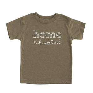 May include: A green short-sleeved t-shirt with the text "home schooled" in white.