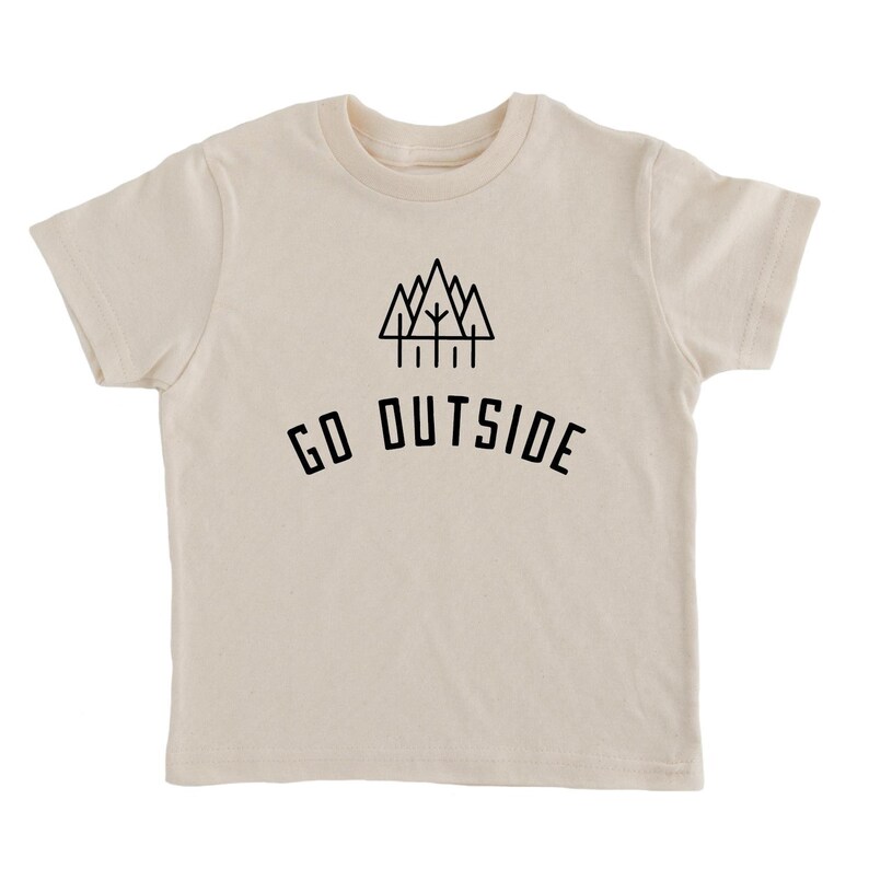 May include: A cream-colored short-sleeved t-shirt with a black graphic of a mountain range and trees. The text "GO OUTSIDE" is printed below the graphic.