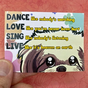 May include: A colorful card with a cute cartoon dog on it. The card has the text "DANCE like nobody's watching LOVE like you've never been hurt SING like nobody's listening LIVE like it's heaven on earth".