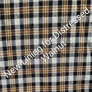 Może przedstawiać: Zbliżenie tkaniny z wzorem w kratę w kolorach czarnym, białym i brązowym. Tekst "New Lining for Distressed Walnut" jest umieszczony ukośnie na tkaninie.