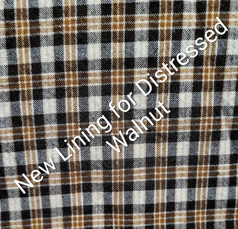 Może przedstawiać: Zbliżenie tkaniny z wzorem w kratę w kolorach czarnym, białym i brązowym. Tekst "New Lining for Distressed Walnut" jest umieszczony ukośnie na tkaninie.