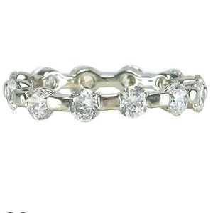 Puede incluir: Una banda de eternidad de plata con una fila de piedras redondas de circonita cúbica transparentes.