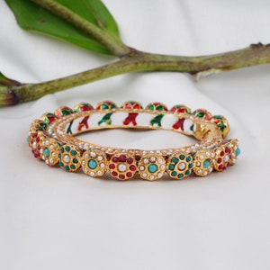 Buy this ruby bangle crafted with 14k yellow gold electromagnetic plating and tarnish resistant