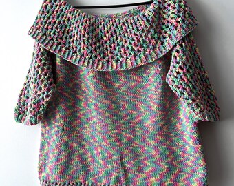 May include: A multi-colored crochet top with a wide, off-the-shoulder neckline and a crocheted collar. The top is made with a variegated yarn in shades of pink, green, yellow, and blue.