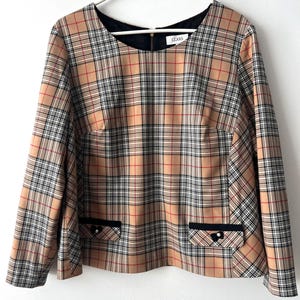 May include: A tan, black, and red plaid top with long sleeves and a black neckline. The top has two front pockets with black trim and a small decorative button. The brand name "CLARS" is visible on the neckline.