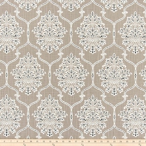 Puede incluir: Una tela beige con un patrón damasco blanco y negro. El patrón presenta un diseño repetitivo de motivos florales estilizados dentro de un marco de celosía.