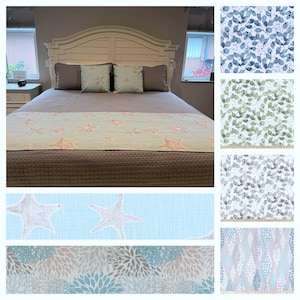 May include: A bed with a white headboard, gray pillows, and two decorative pillows with a starfish design. A light green bed runner with starfish and several fabric samples with leaf and floral patterns are also shown.