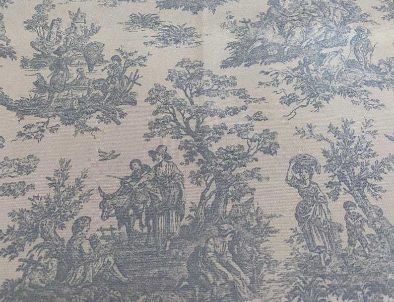 May include: A light beige fabric with a blue toile pattern. The design depicts pastoral scenes with figures, trees, and animals. The overall aesthetic is reminiscent of classic French country decor.