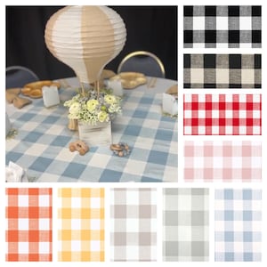 May include: A round tablecloth featuring a large blue and white buffalo check pattern. The image also displays a collection of fabric swatches in various colors including black, red, pink, orange, yellow, gray, and light blue buffalo check.