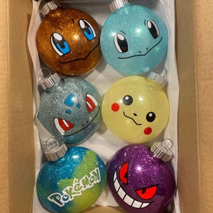 May include: Six round, glittery Christmas baubles featuring different Pokemon characters. The baubles are brown, blue, yellow, purple, and two shades of blue. The baubles are decorated with the Pokemon characters Pikachu, Bulbasaur, Squirtle, Charmander, and Gengar.