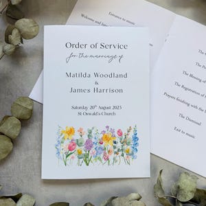 May include: A wedding order of service. The cover reads "Order of Service for the marriage of Matilda Woodland & James Harrison", with a floral border. The date is Saturday 20th August 2025, at St Oswald's Church.