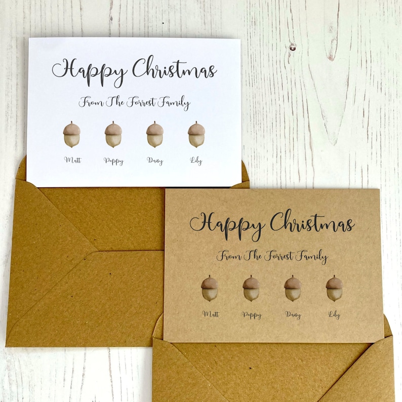 Op de afbeelding: Twee kerstkaarten met een bruine kraftpapier achtergrond en witte tekst. De tekst luidt "Prettige Kerst" en "Van de familie Forrest". Elke kaart heeft vier eikels met namen eronder: Matt, Poppy, Duty, Lily.
