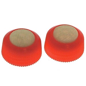 Könnte beinhalten: Zwei rote Plastikflaschenverschlüsse mit einem beigefarbenen Schaumstoffeinsatz. Die Verschlüsse haben eine geriffelte Kante.