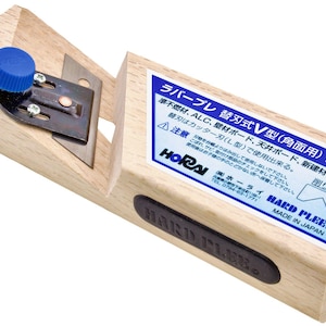 May include: A wooden V-shaped plane with a metal blade and a blue adjustment knob. The tool has a rectangular body with a black label that reads "HARD PLEE" and a blue and white label with Japanese text.