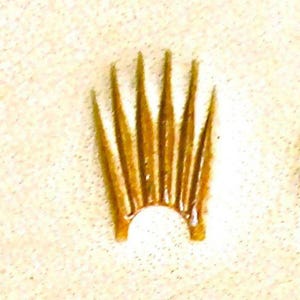 Könnte beinhalten: Eine goldfarbene Krone mit einer spitzen Spitze und einer abgerundeten Basis. Die Krone hat 12 Spitzen.