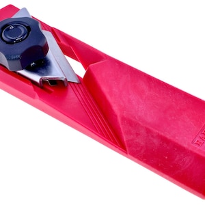 May include: A red mandoline slicer with a black knob and a silver blade. The slicer has a rectangular base and a sloped cutting surface. The text "RAKUDA MADE IN JAPAN" is visible on the side.