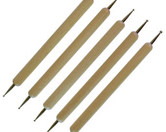 May include: Five double-ended dotting tools with wooden handles. Each tool has a metal tip on both ends, one pointed and the other rounded. The tools are arranged diagonally against a white background.