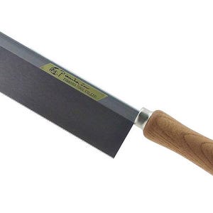 Può includere: Sega giapponese a trazione con una lama grigio scuro e un manico in legno. La lama ha denti fini per un taglio di precisione. L'impugnatura è in legno marrone chiaro ed è sagomata ergonomicamente per una presa comoda.