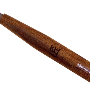 May include: A wood carving tool with a curved blade and a wooden handle. The handle is brown and has a small, rectangular, black label with the text "11" on it.