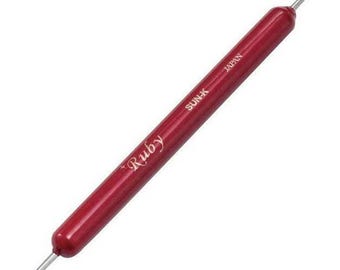 May include: A red, double-ended tool with a pointed tip on one end and a rounded tip on the other. The tool is labeled "Ruby" and "SUN-K JAPAN".