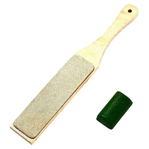 May include: A wooden sharpening tool with a grey abrasive surface and a green honing compound. The tool is approximately 30 cm long.